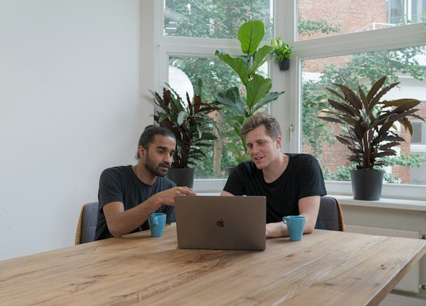 A friendly mortgage broker discussing loan options with a couple at a cozy office setting.